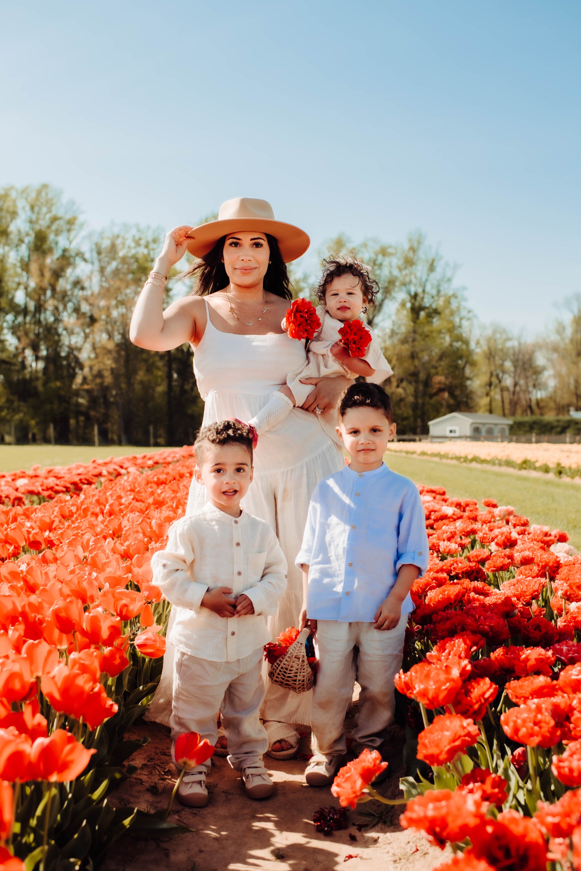 Mom with her 3 children under 5 years old in flower field