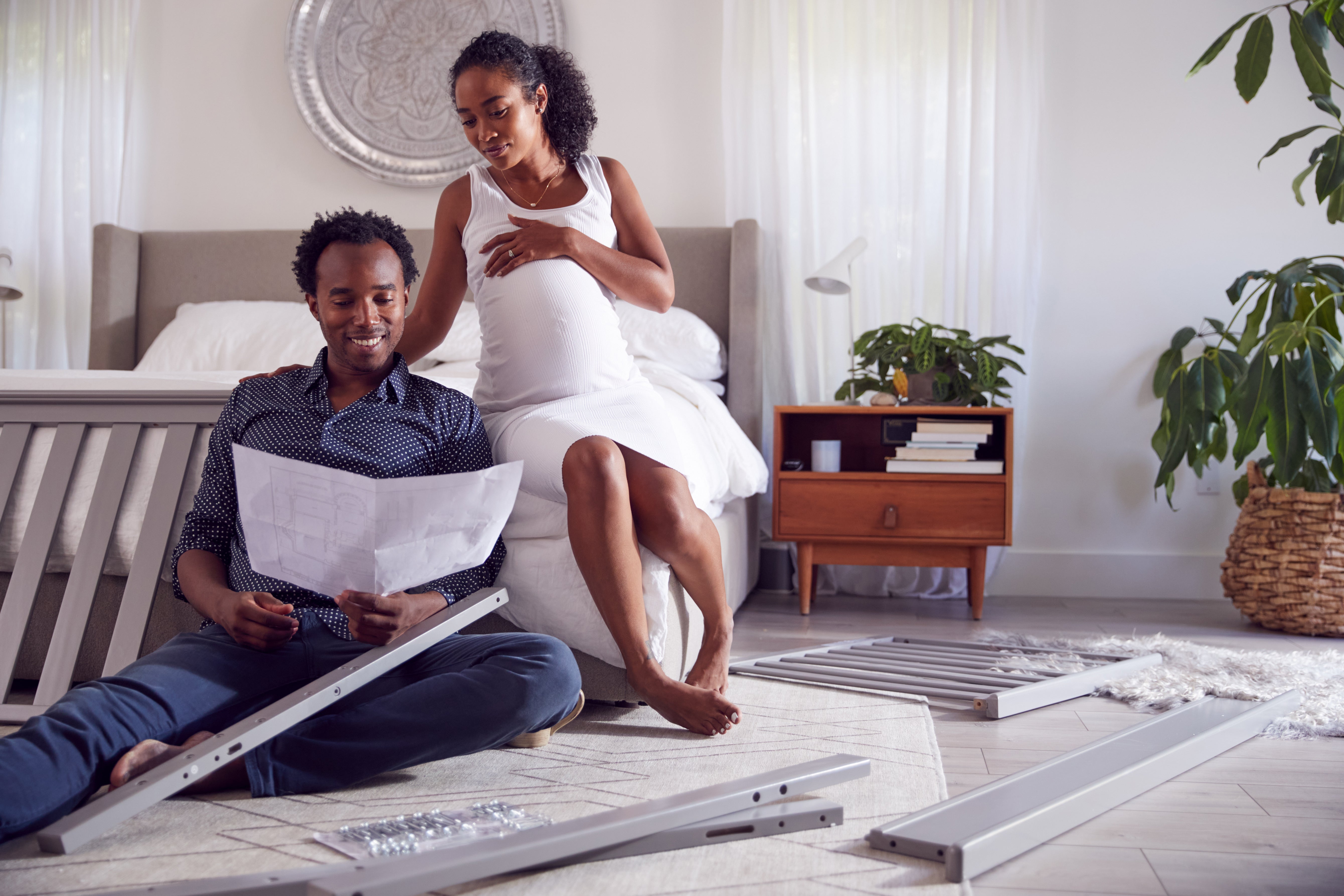 Woman and man sitting down reading instructions together on building furniture