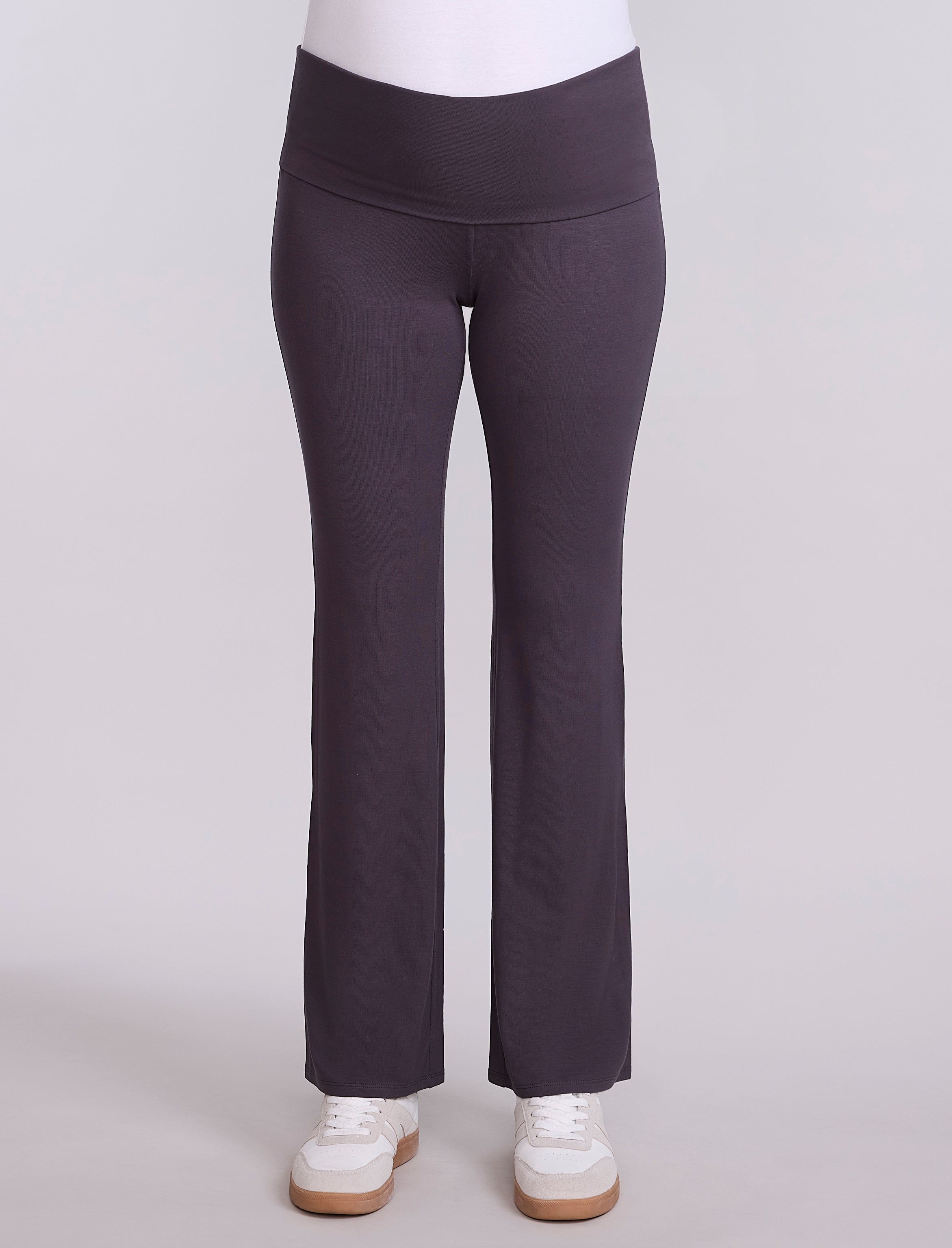 Dark gray pants worn by a pregnant woman on a light gray background