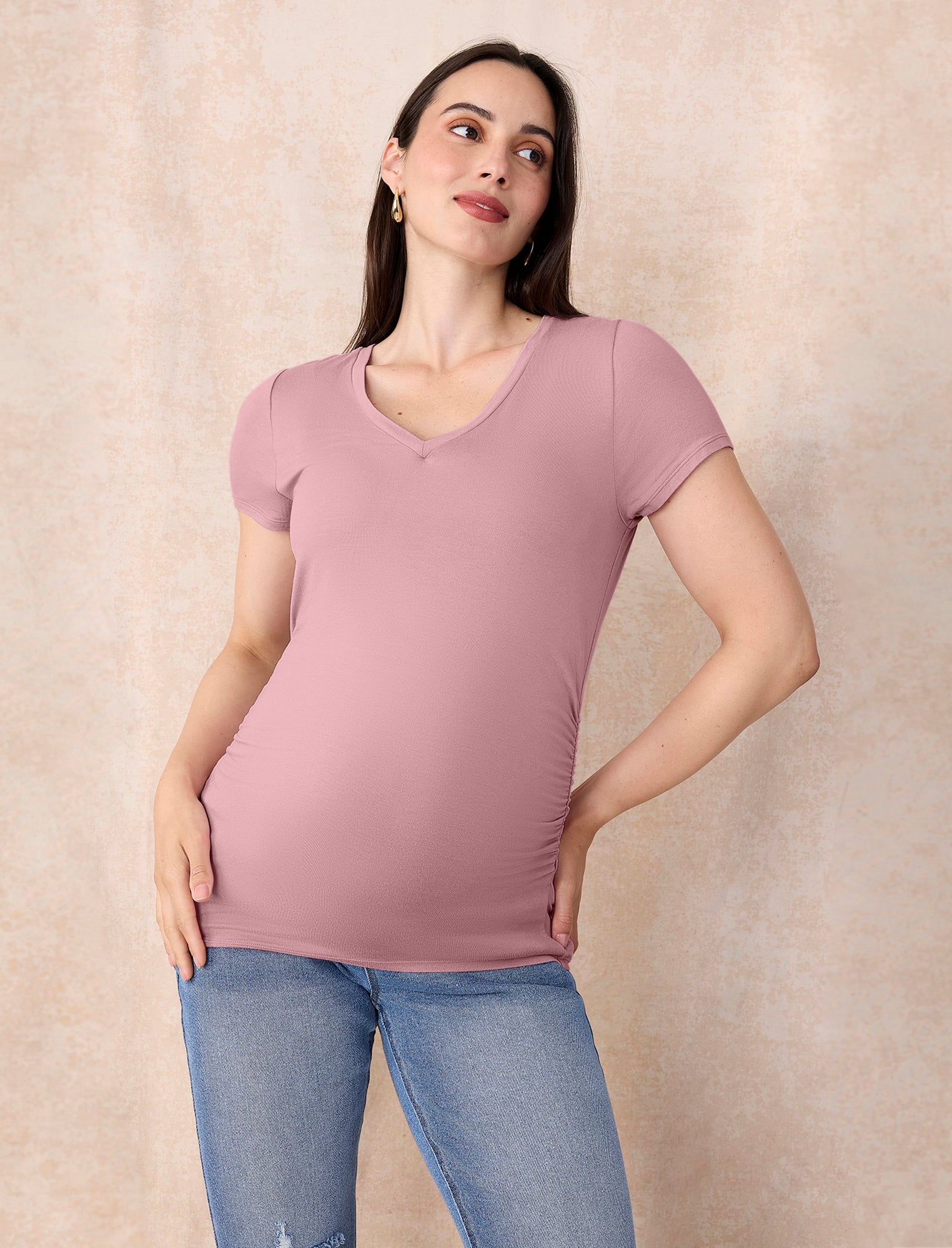 Pregnant woman wearing light pink t-shirt and jeans