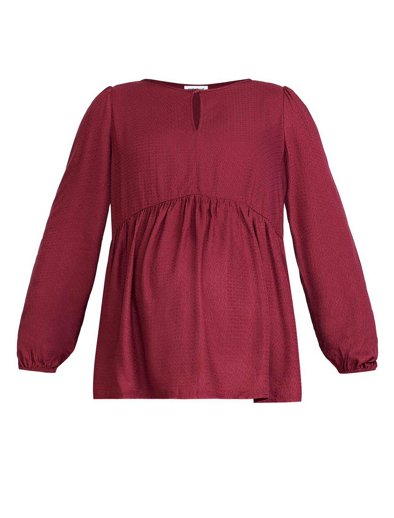 Pregnant woman wearing a burgundy long-sleeve top on a light gray background