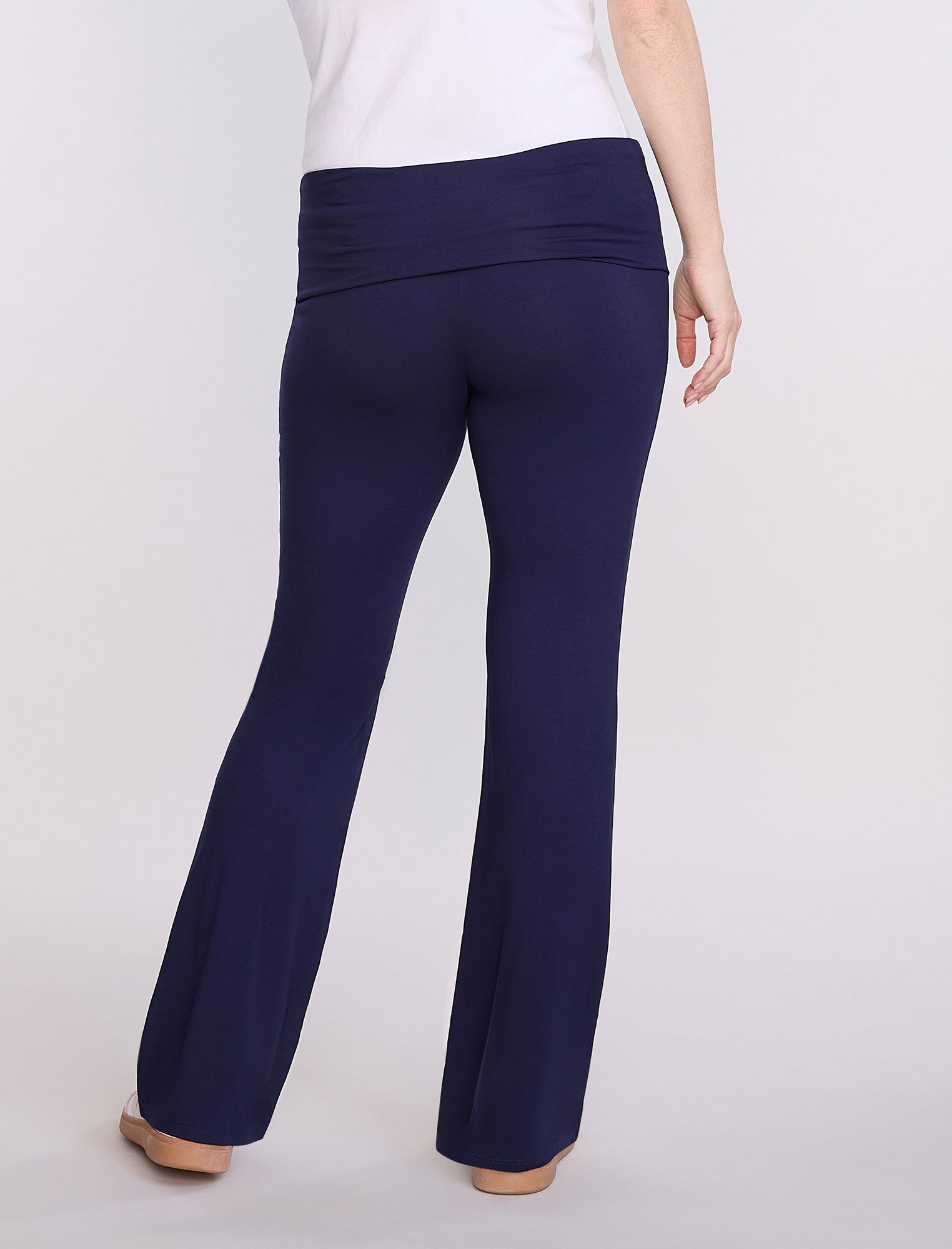 Navy blue maternity pants worn by a pregnant woman on a white background