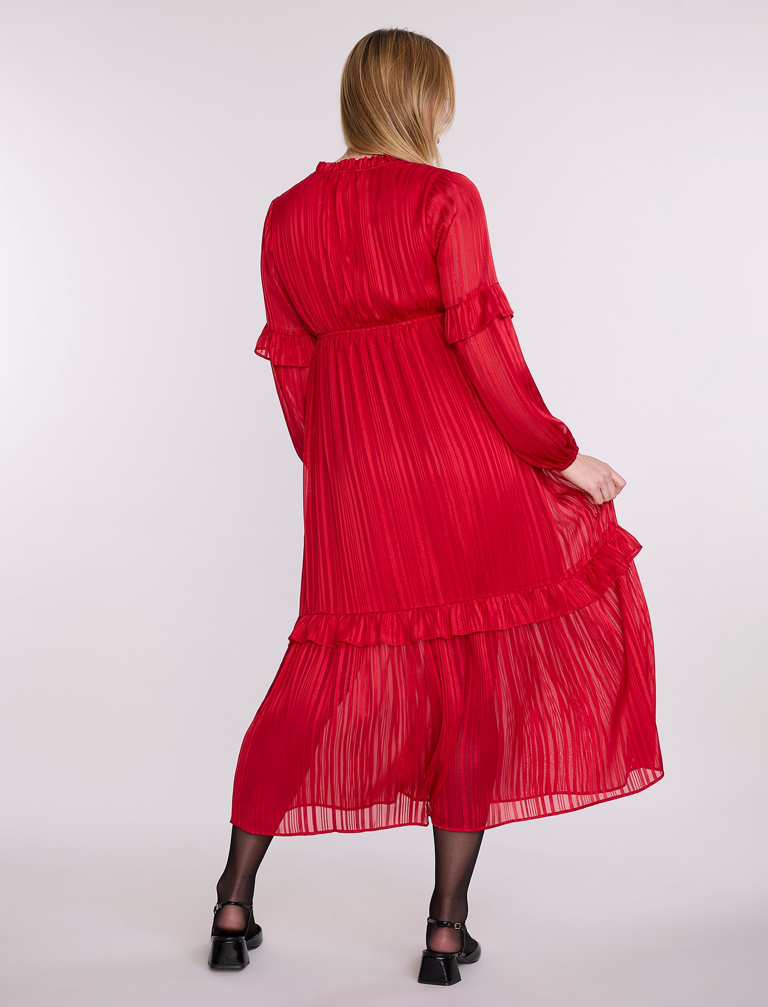 Pregnant woman wearing a red dress on a white background