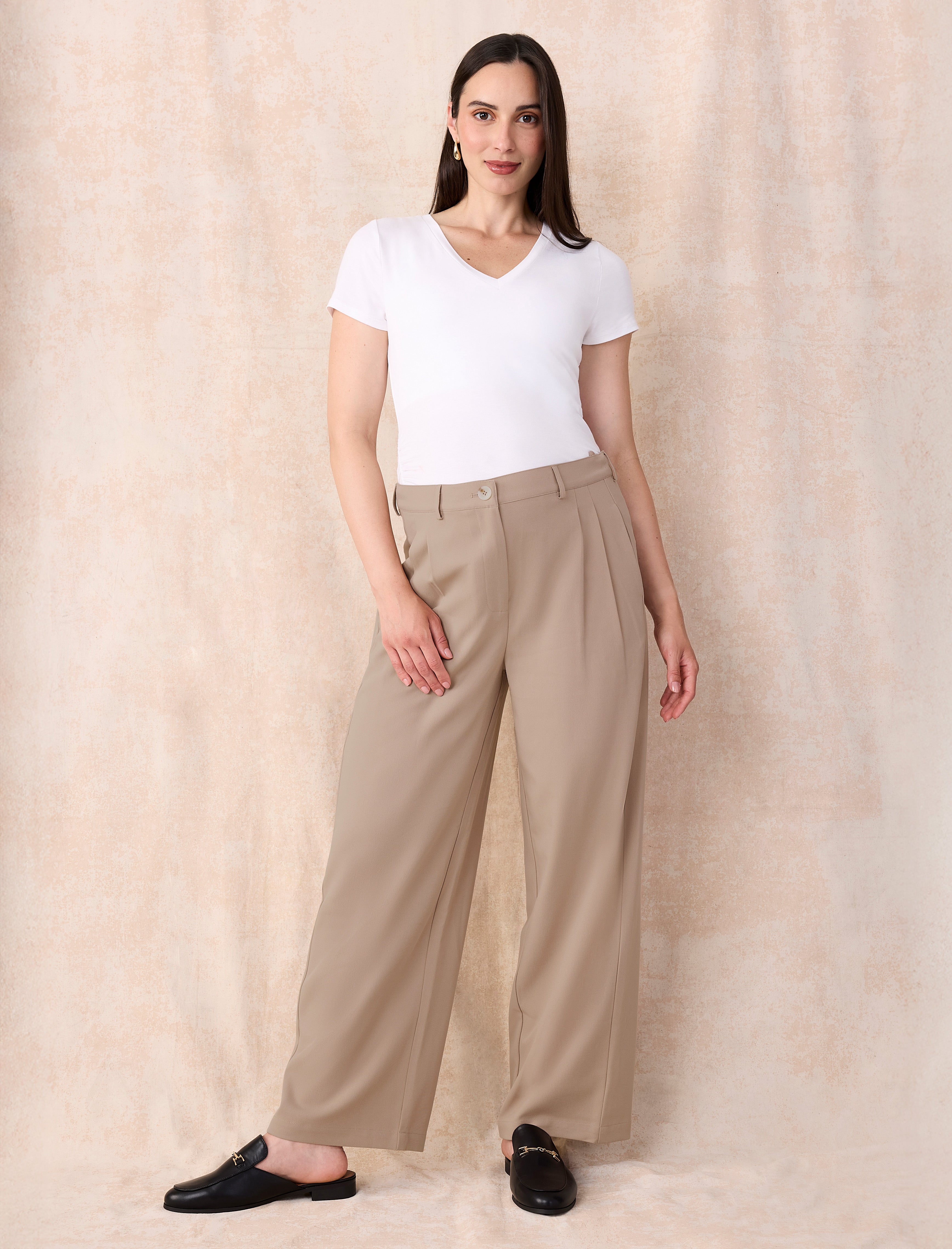 White maternity t-shirt and beige wide-leg maternity pants worn by a person on a white background
