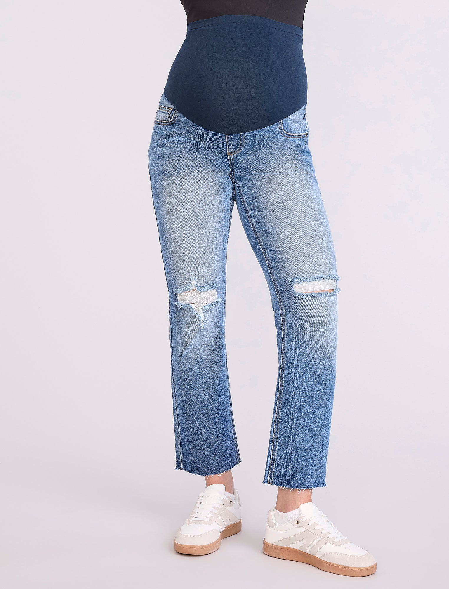 Blue jeans worn by a pregnant woman on a white background