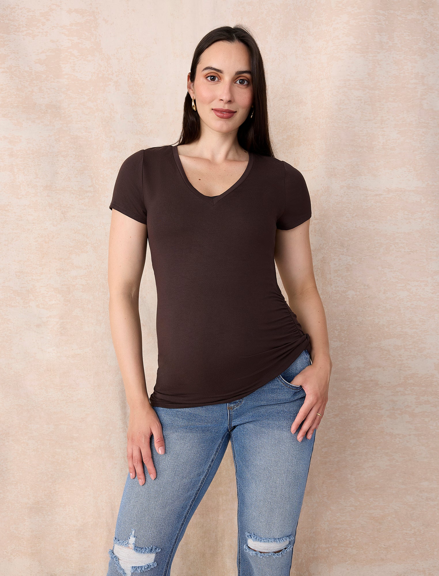 Blue jeans  and brown t-shirt worn by a pregnant woman on a white background