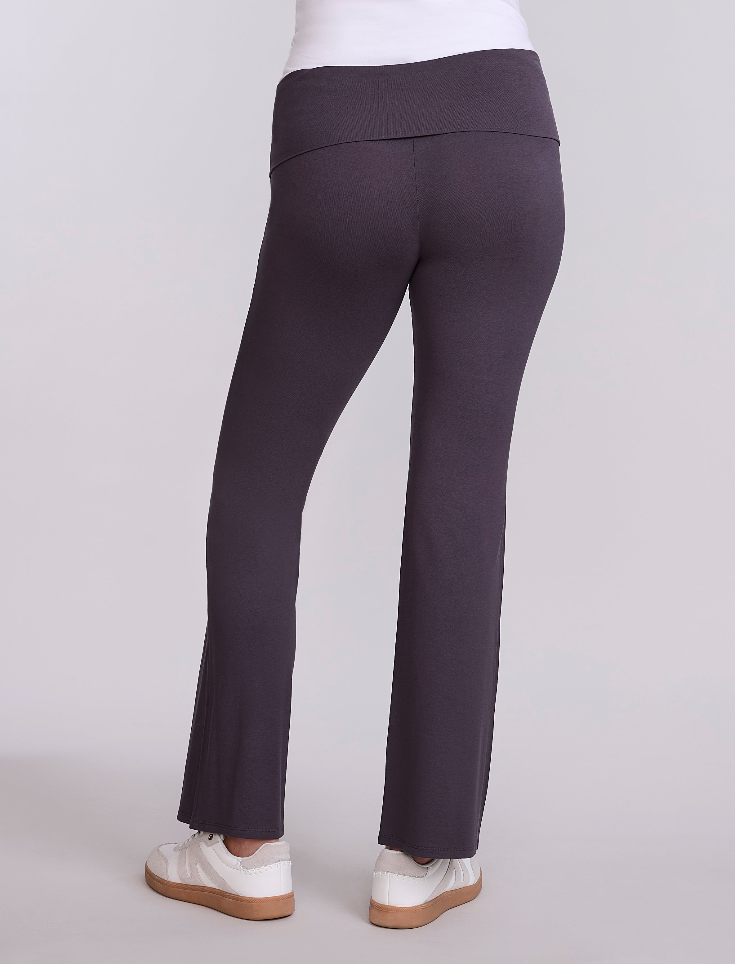 Dark gray pants worn by a pregnant woman on a light gray background