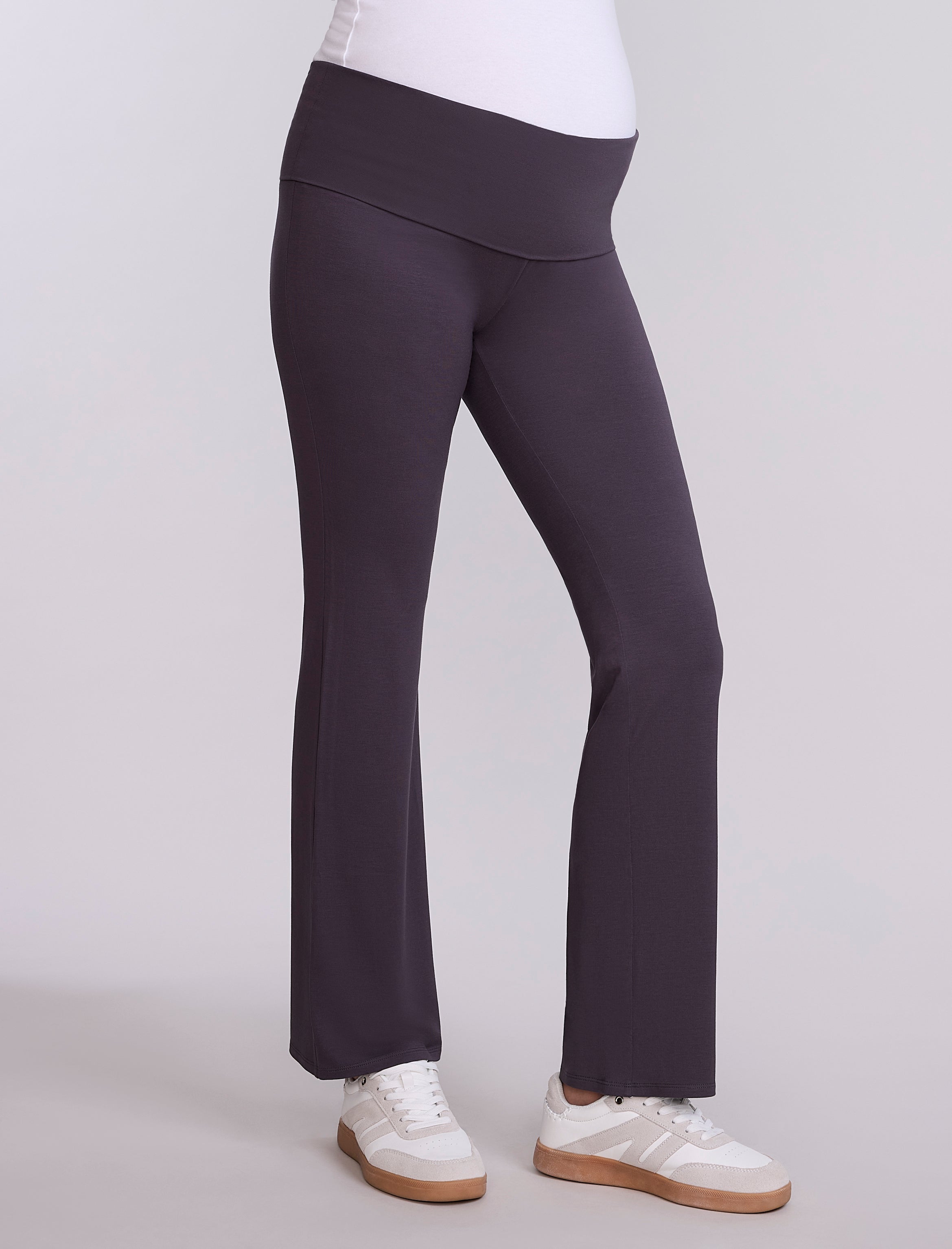 Dark gray pants worn by a pregnant woman on a light gray background