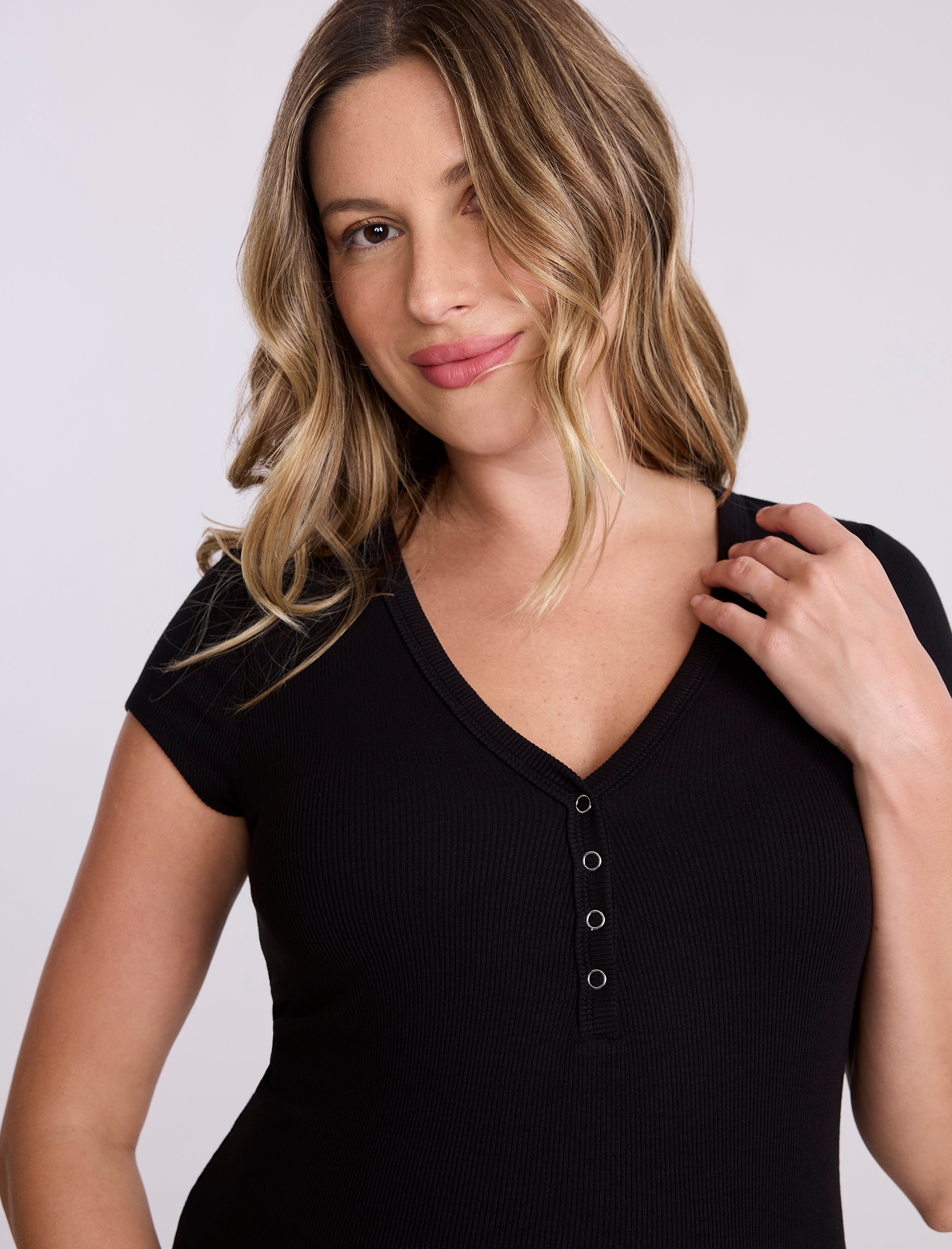 Woman wearing a black top with a plain background