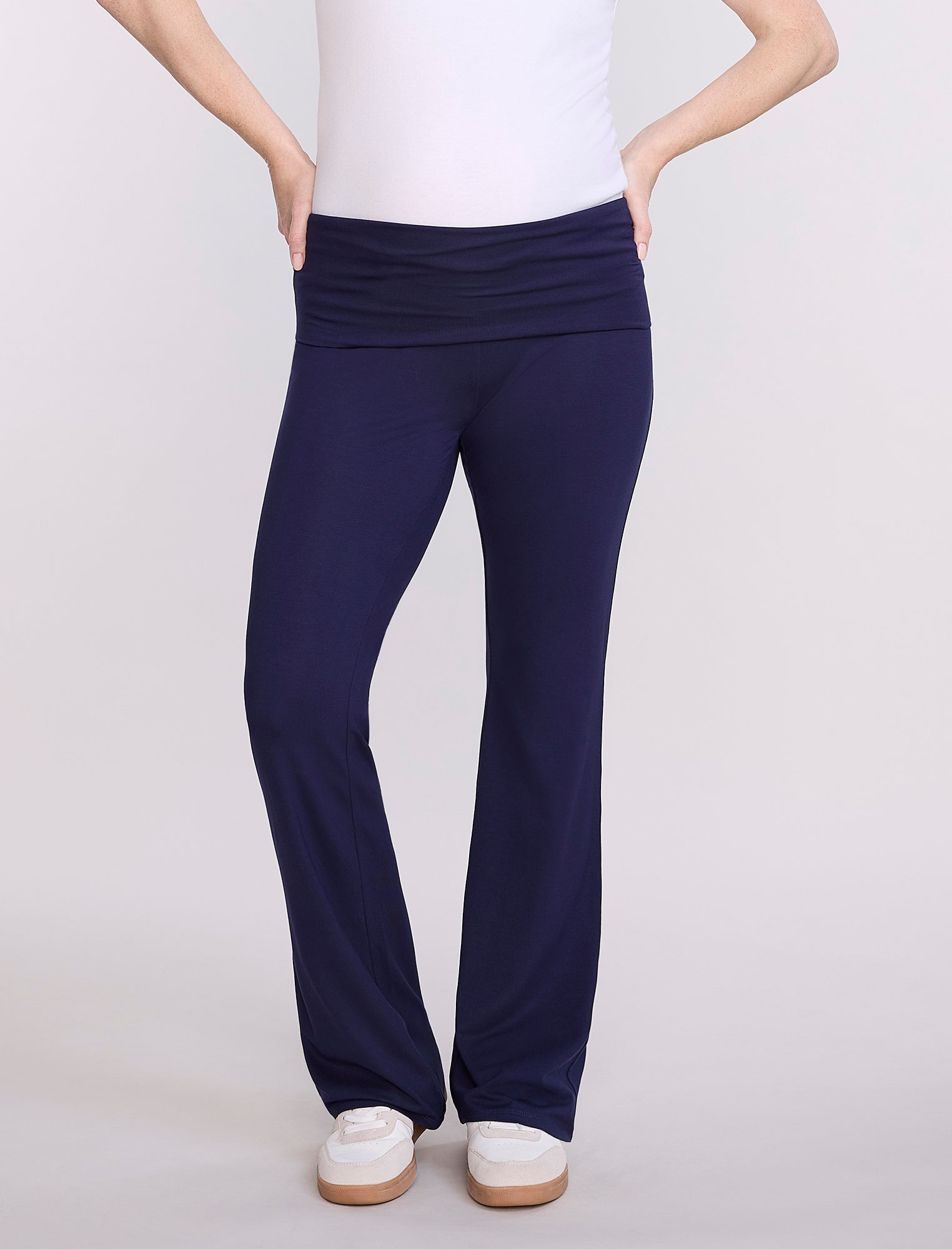 Navy blue maternity pants worn by a pregnant woman on a white background